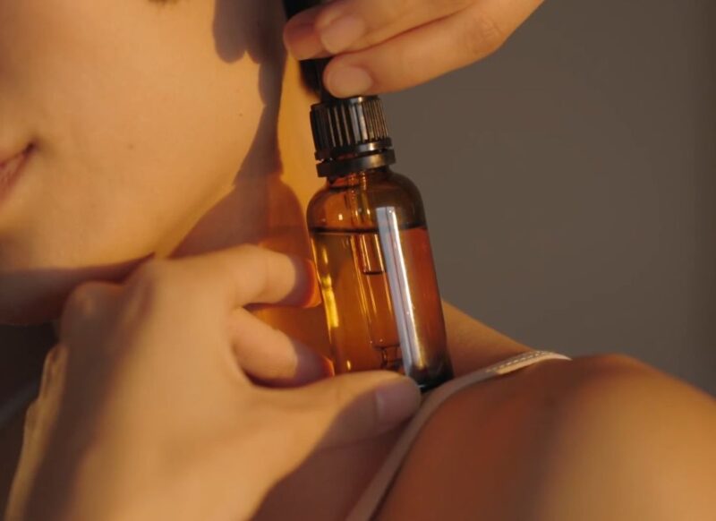devojka drži na ramenu esencijalno ulje